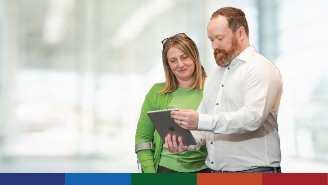 An image of two staff members looking at a tablet computer.