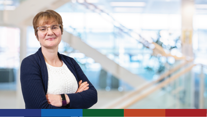 A photograph of a Scottish Government staff member dressed in a suit with an office background behind.