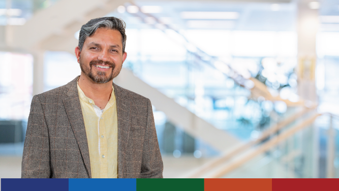 A photograph of a Scottish Government staff member with a modern office stairwell in the background.