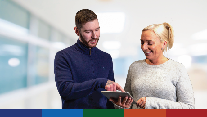 Two members of staff looking at a tablet computer.